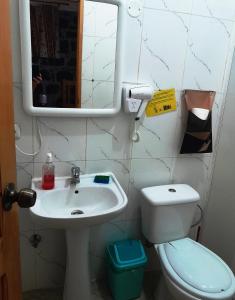 a bathroom with a sink and a toilet and a mirror at Pousada Villa Concetta in Cidade Velha