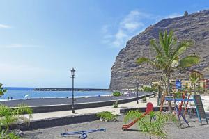 - une plage avec des chaises, un palmier et l'océan dans l'établissement Coral, à Puerto