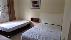 two beds in a small room withermottermottermott at Sitío Paraíso in Jambeiro