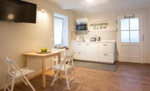 a kitchen with a table and chairs and a kitchen with white cabinets at Castle Rock Bled apartment in Bled