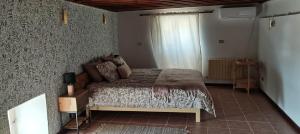 una camera con un letto in una stanza con una finestra di Beit El Ezz - la petite a Ouled Yaneg