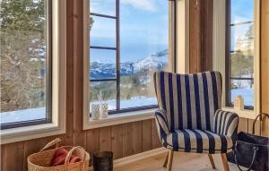 une chaise dans une chambre avec vue sur les montagnes enneigées dans l'établissement Lovely Home In Tuddal With House A Mountain View, à Tuddal