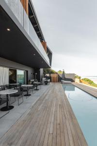 un patio esterno con piscina, tavoli e sedie di Escape to the Beach a Wilderness