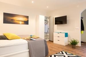 a bedroom with a bed and a tv on a wall at Castle Rock Bled apartment in Bled