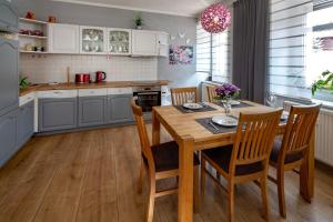 a kitchen with a wooden table and chairs in a kitchen at Erzgebirge Apartments Sehmatal in Sehma