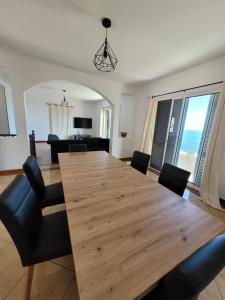 ein Esszimmer mit einem großen Holztisch und Stühlen in der Unterkunft Maison avec vue exceptionnelle sur l'océan - 5 mn du centre ville in Santa Cruz