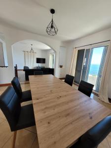 a dining room with a large wooden table and chairs at Maison avec vue exceptionnelle sur l'océan - 5 mn du centre ville in Santa Cruz +16 photos