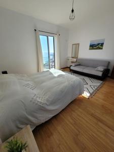 a bedroom with a large bed and a couch at Maison avec vue exceptionnelle sur l'océan - 5 mn du centre ville in Santa Cruz