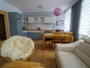 a kitchen and living room with a couch and a table at Erzgebirge Apartments Sehmatal in Sehma +9 photos