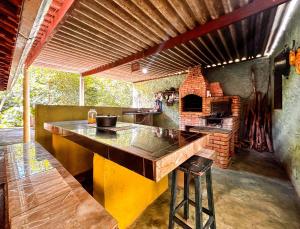 a kitchen with a large counter with a brick oven at Chacara com lazer e conforto em Joanopolis SP in Joanópolis