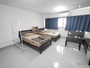 1 dormitorio con 2 camas y piano en Muangthong inn at popupar Condo, en Ban Bang Phang 1 foto más