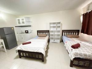 2 camas en una habitación con cocina en Muangthong inn at popupar Condo, en Ban Bang Phang