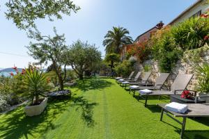 a row of lounge chairs sitting on a lawn at Villa Tomislav in Split