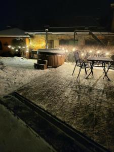 a table and chairs in the snow at night at LULU GAST HAUS in Ventspils