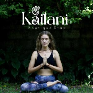 una mujer sentada en la hierba haciendo una meditación en Kailani boutique stay, en Varkala