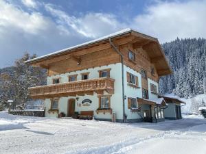 a building with a wooden roof in the snow at Winklhütte in Forstau