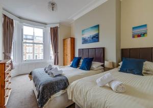 a bedroom with two beds with blue pillows at 45 The Square Holiday Apartments in Scarborough