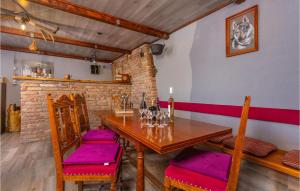 un comedor con mesa de madera y sillas con cojines morados en Amazing Apartment In Cavle With Kitchen, en Čavle