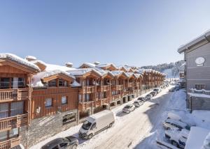 a row of buildings with cars parked in the snow at Cosy Home Center 1850-Croisette in Courchevel