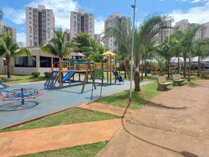 a playground in a park with palm trees and benches at Siene Rosa in Barretos