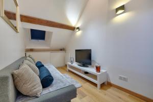 a living room with a couch and a tv at Studio Olivia in Montgeron