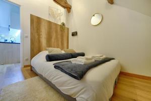 a large white bed in a room with a mirror at Studio Olivia in Montgeron