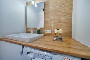a bathroom with a sink and a washing machine at Studio Olivia in Montgeron