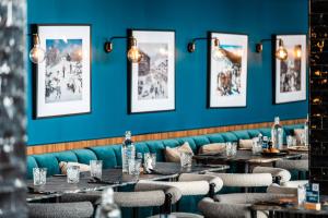 Fahrenheit Seven Val Thorens في فال تورن: صف طاولات في مطعم بجدران زرقاء
