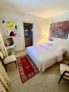 a bedroom with a white bed and a chair at Casa de los Bates in Motril