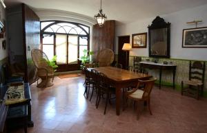 uma sala de jantar com uma mesa de madeira e cadeiras em El Recer em Sant Pau dʼOrdal