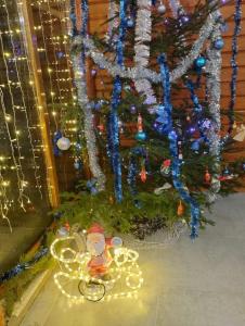 ein Weihnachtsbaum mit einer Santa-Klausel auf einem Dreirad davor in der Unterkunft Gostynnyi Dvir u Marichky in Laseschtschyna