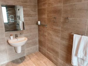 a bathroom with a sink and a mirror at Sky Suites in Accra