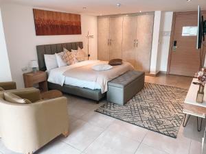 a bedroom with a bed and a couch and a chair at Sky Suites in Accra