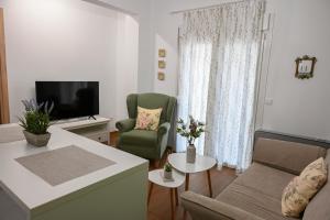 ein Wohnzimmer mit einem Sofa und einem TV in der Unterkunft Joanna's apartments in Alexandroupoli