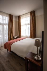 1 dormitorio con 1 cama blanca grande y ventanas en De 4 seizoenen, en Loenen