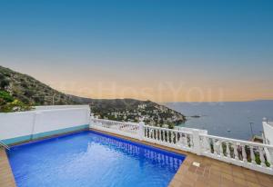 a swimming pool with a view of the ocean at Magnifique Maison Bramer 14, Roses - WeHostYou in Roses