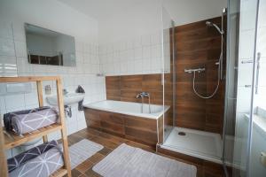 a bathroom with a tub and a sink and a shower at Erzgebirge Apartments Sehmatal in Sehma