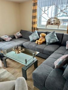 uma sala de estar com um urso de peluche sentado num sofá em Hartensteiner Straße 14 em Lößnitz