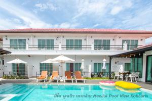 un hotel con una piscina con sillas y sombrillas en MeeJai Pool View Kohlarn, en Koh Larn