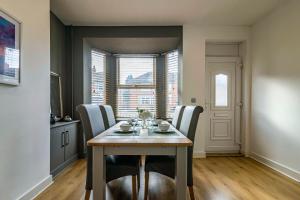 een eetkamer met een tafel en stoelen bij 3 BR Terraced House in Beeston with Easy City Centre Access in Nottingham