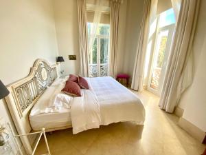 a bedroom with a bed with white sheets and red pillows at Casa de los Bates in Motril