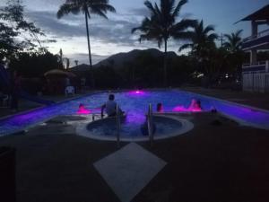 een groep mensen die 's nachts in een zwembad zitten bij Hotel Estambul in Los Guayabos
