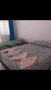 een bed met een deken erop in een slaapkamer bij Hotel Estambul in Los Guayabos