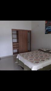 een slaapkamer met een bed en een houten kast bij Hotel Estambul in Los Guayabos