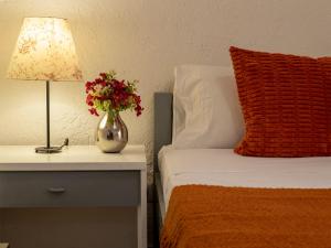 un letto con un vaso di fiori su un comodino di Apartment F4-F1 by Interhome a Marinella