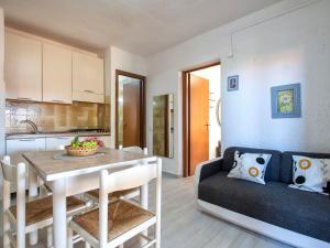 una cucina e un soggiorno con tavolo e divano di Apartment F4-F1 by Interhome a Marinella