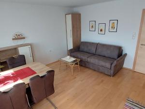 ein Wohnzimmer mit einem Sofa und einem Tisch in der Unterkunft Apartment Rupertus-2 by Interhome in Maishofen