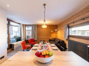 uma sala de jantar com uma mesa com uma taça de fruta em Apartment Le Pramecou - Val Claret-8 by Interhome em Tignes