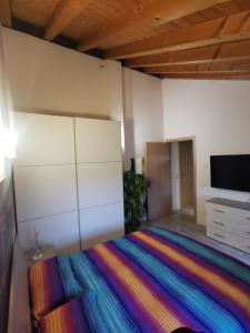 1 dormitorio con 1 cama con una manta colorida en Luxury Home, en Codognè