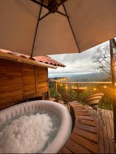bañera en una terraza con sombrilla en La Julita Glamping, en La Mesa